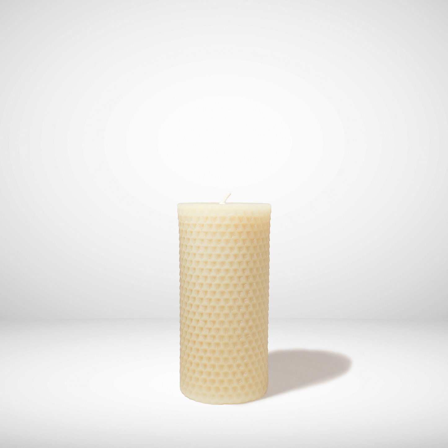Beeswax candle with honeycomb pattern on a white background