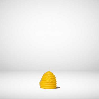 A yellow beeswax candle shaped like a beehive, set against a plain background.