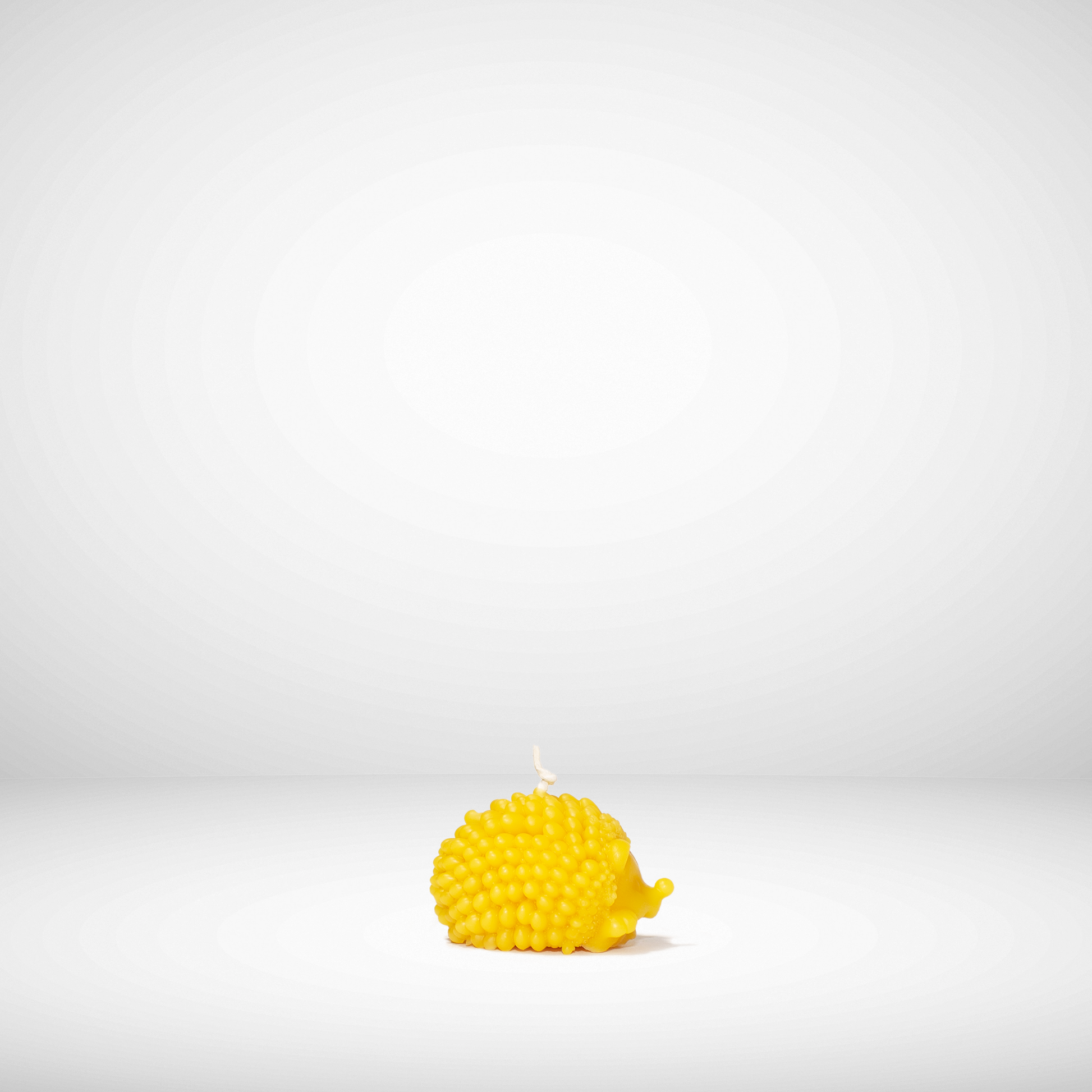 Yellow textured candle on a white background