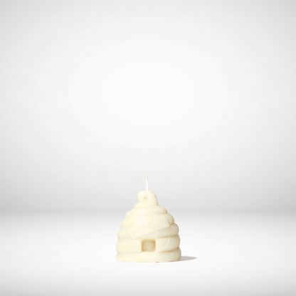 Beehive-shaped beeswax candle on a white background