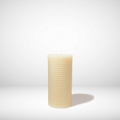 Beeswax candle with honeycomb pattern on a white background