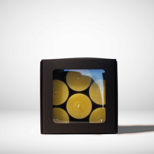 A black box containing yellow beeswax tea light candles visible through a clear window.