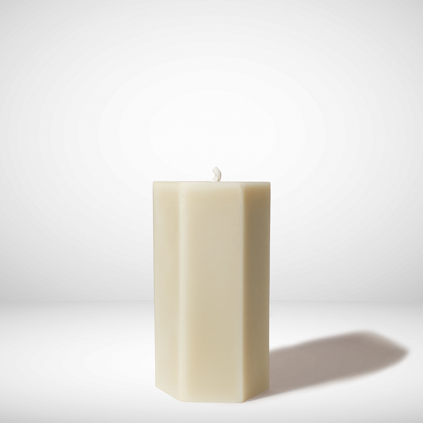 Beige rectangular beeswax candle on a white background