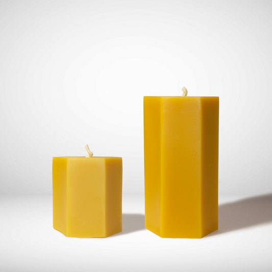 Two hexagonal beeswax candles on a white background