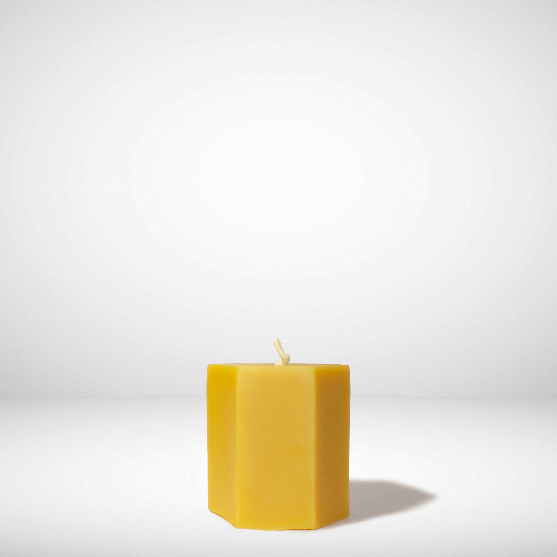 Yellow beeswax candle on a white background