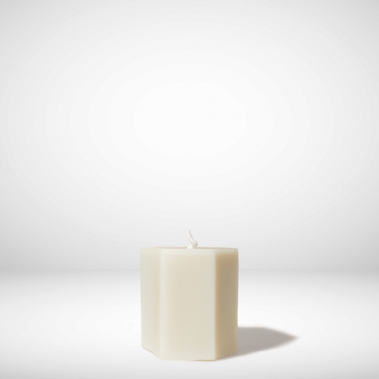 White hexagonal beeswax candle on a white background