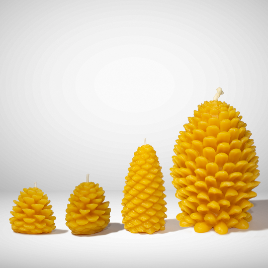 Set of four yellow pinecone-shaped beeswax candles on a white background