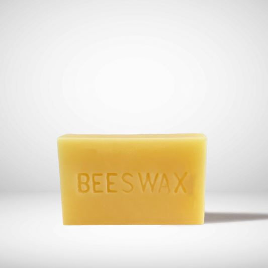 A yellow brick of pure Canadian beeswax with the words 'BEESWAX' embossed on the surface.