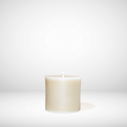 White beeswax candle on a white background